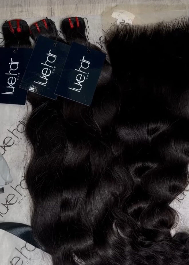 Black hair extensions with 'Juel' branding on a textured surface