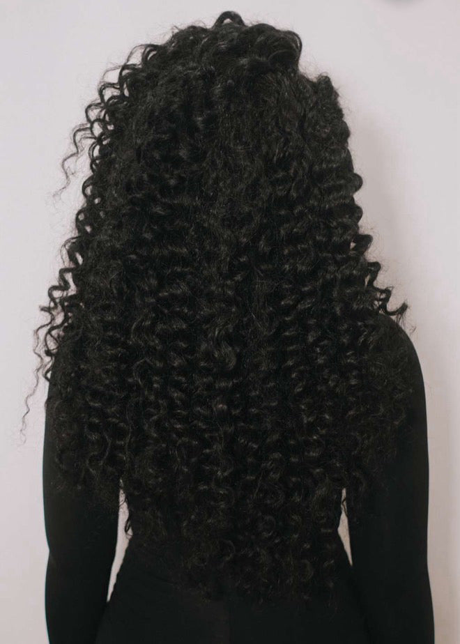 Person with long, curly black hair on a white background